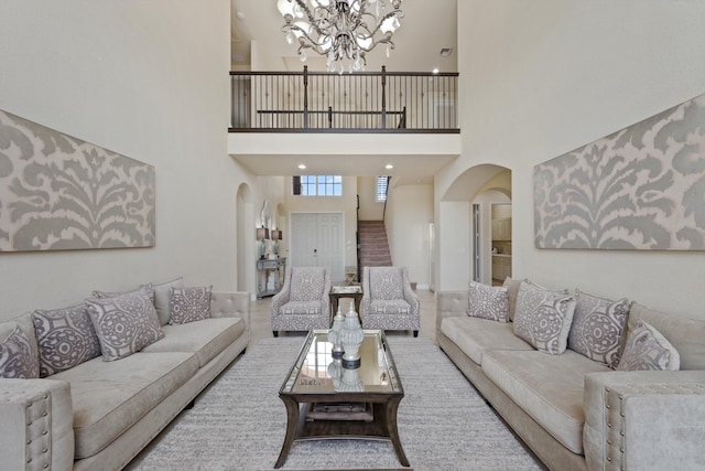 living room with a towering ceiling and a notable chandelier