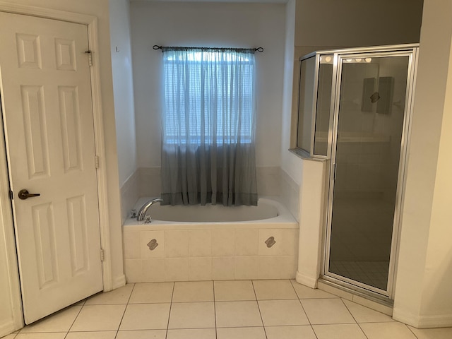 bathroom featuring tile patterned floors, a stall shower, and a bath