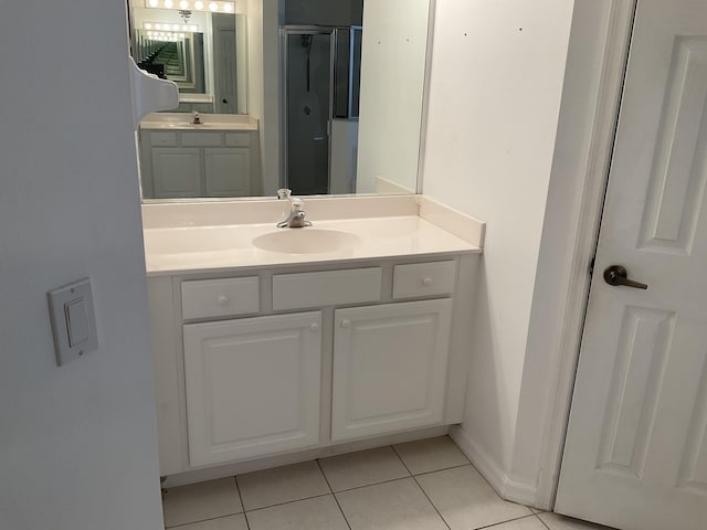 full bathroom with tile patterned floors, baseboards, a shower stall, and vanity