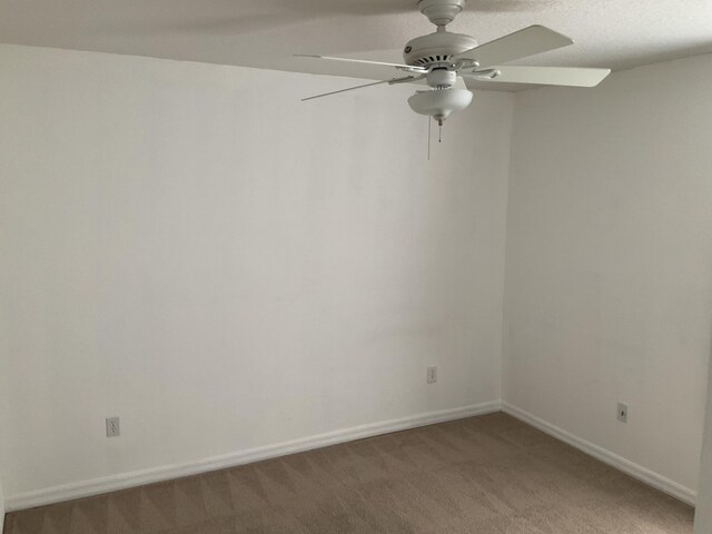 unfurnished room featuring a ceiling fan, light colored carpet, and baseboards