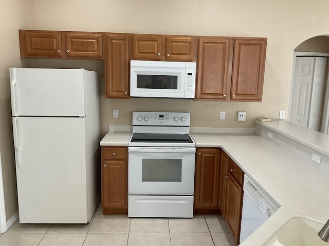 kitchen with white appliances and light tile patterned flooring