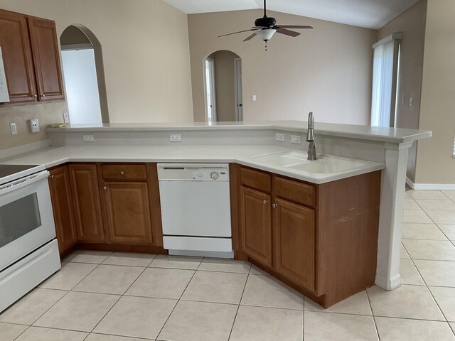 kitchen featuring white appliances, light tile patterned floors, and brown cabinets