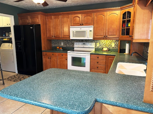 kitchen featuring washer / clothes dryer, tasteful backsplash, sink, and white appliances