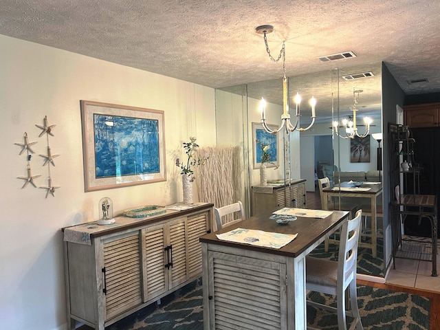 kitchen with a kitchen island, a textured ceiling, an inviting chandelier, and decorative light fixtures