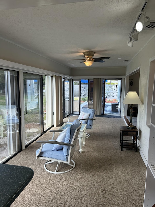 sunroom featuring rail lighting and ceiling fan