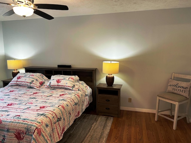 bedroom featuring ceiling fan, dark hardwood / wood-style floors, and a textured ceiling