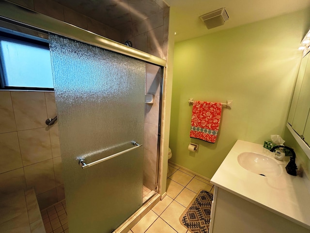 bathroom with tile patterned flooring, vanity, a shower with door, and toilet