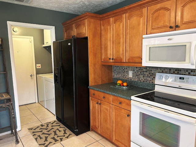 kitchen with independent washer and dryer, white appliances, decorative backsplash, and light tile patterned floors