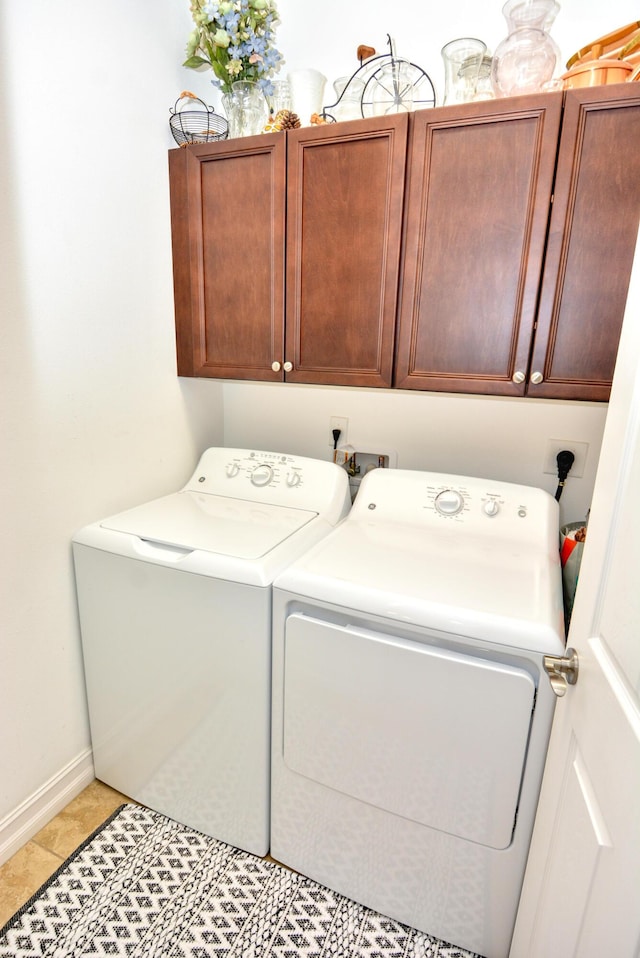 laundry room with cabinets, light tile patterned floors, and independent washer and dryer