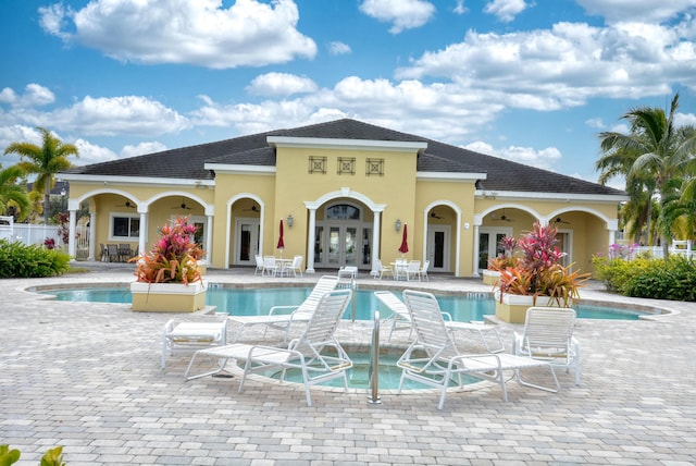 view of pool with french doors, ceiling fan, a jacuzzi, and a patio