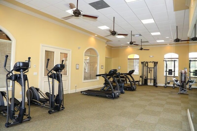 gym with a paneled ceiling and ornamental molding