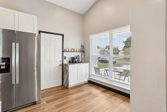 kitchen featuring stainless steel refrigerator with ice dispenser, white cabinetry, and light hardwood / wood-style flooring