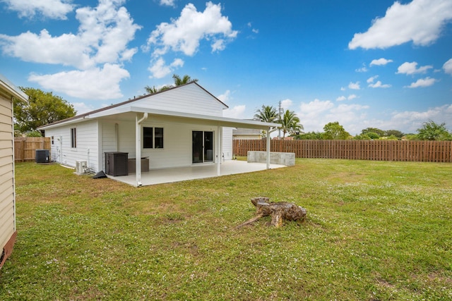 back of property with a lawn, cooling unit, and a patio area