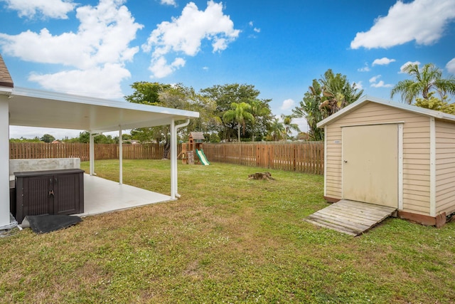 view of yard featuring a storage shed, a patio area, and a playground