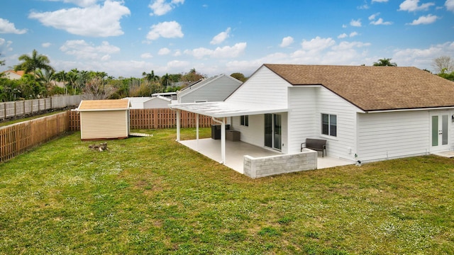 rear view of house featuring cooling unit, a yard, a storage shed, and a patio