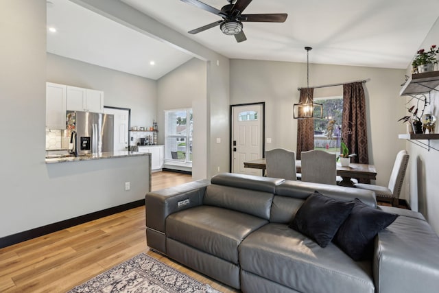 living room featuring ceiling fan, vaulted ceiling with beams, and light wood-type flooring