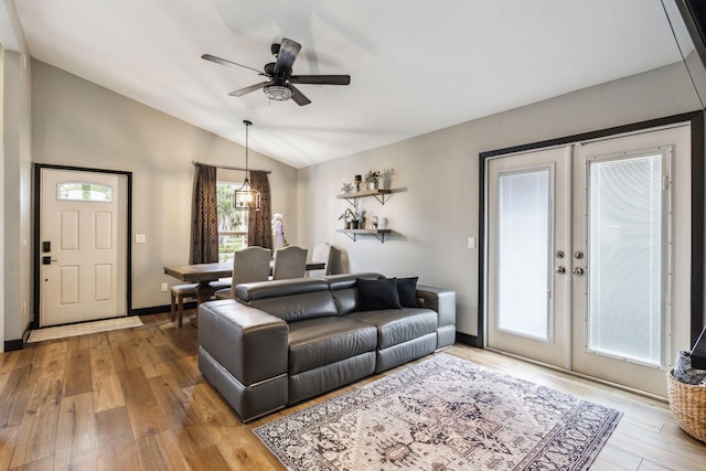 living room featuring ceiling fan, wood-type flooring, lofted ceiling, and french doors