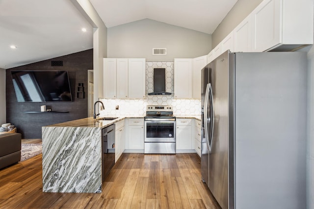 kitchen with white cabinetry, appliances with stainless steel finishes, tasteful backsplash, wall chimney range hood, and sink