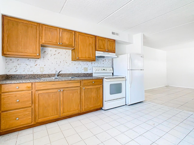 kitchen with visible vents, brown cabinets, a sink, under cabinet range hood, and white appliances