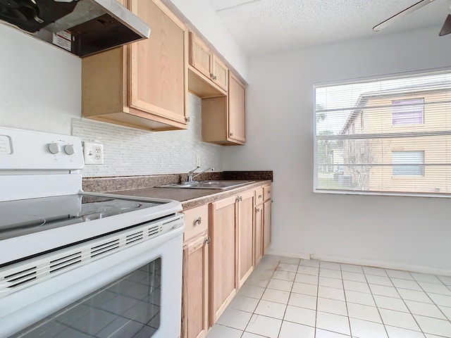 kitchen featuring ventilation hood, light brown cabinets, electric range, a sink, and backsplash