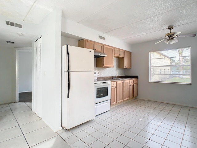 kitchen with under cabinet range hood, visible vents, white appliances, and light tile patterned flooring