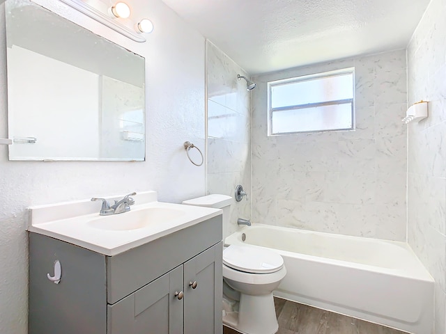 full bathroom with toilet, shower / bathtub combination, a textured ceiling, wood finished floors, and vanity