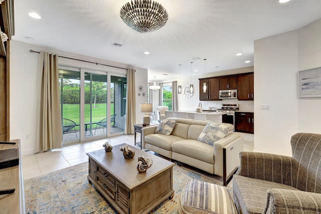 living room featuring light tile patterned flooring and a chandelier