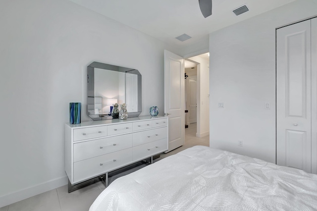 tiled bedroom with ceiling fan and a closet