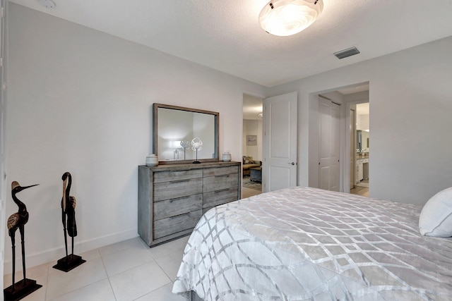 bedroom with a textured ceiling and connected bathroom