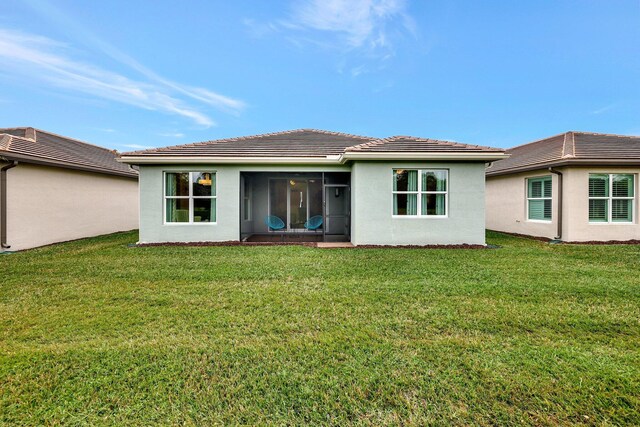 rear view of house featuring a lawn