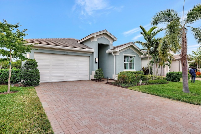 single story home featuring a garage and a front lawn