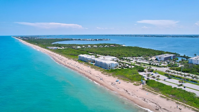 drone / aerial view featuring a beach view and a water view