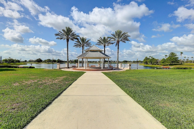 view of dock with a gazebo, a yard, and a water view