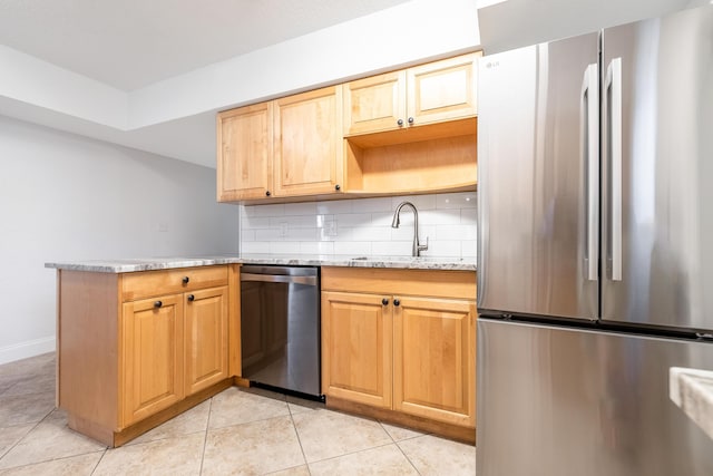 kitchen featuring appliances with stainless steel finishes, light stone counters, sink, light tile patterned flooring, and tasteful backsplash