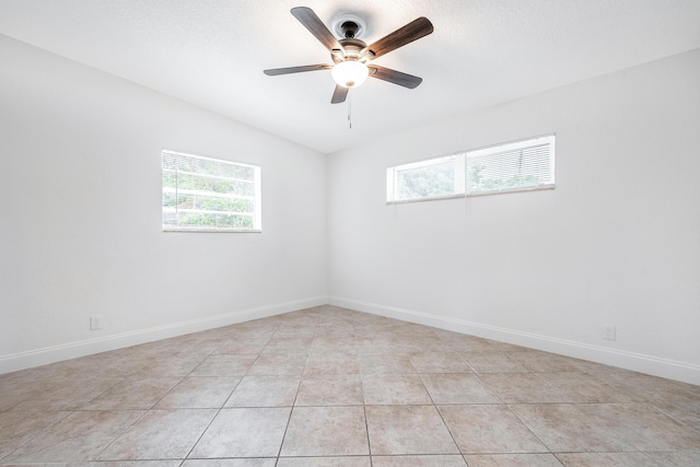 tiled spare room featuring ceiling fan