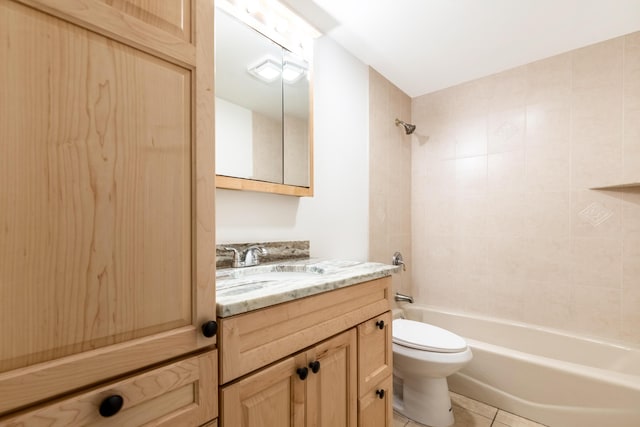 full bathroom with tiled shower / bath, tile patterned flooring, vanity, and toilet