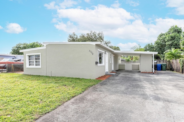 view of side of home with a carport and a lawn