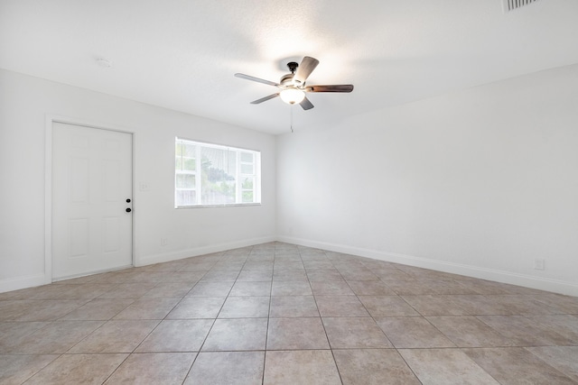 tiled empty room featuring ceiling fan