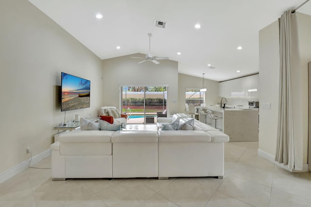 tiled living room featuring ceiling fan, high vaulted ceiling, and sink