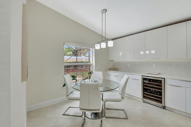 dining area with high vaulted ceiling, wine cooler, and light tile patterned floors