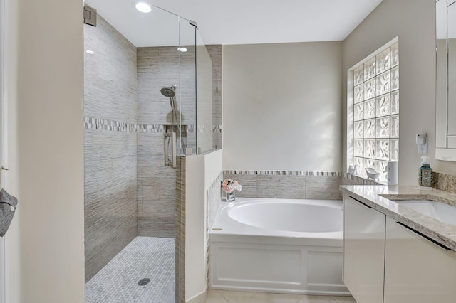 bathroom featuring tile patterned flooring, vanity, and shower with separate bathtub