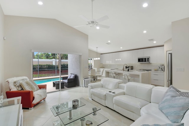 tiled living room featuring sink, high vaulted ceiling, and ceiling fan