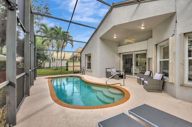 view of pool featuring a patio area, ceiling fan, an outdoor hangout area, and glass enclosure