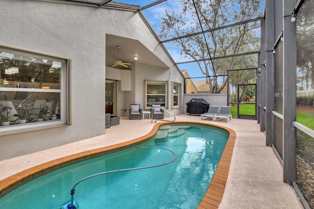 view of swimming pool featuring ceiling fan, a patio, and glass enclosure