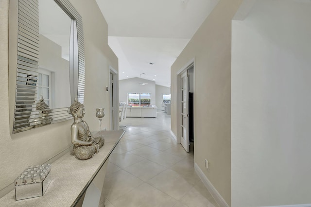 hall featuring lofted ceiling and light tile patterned floors