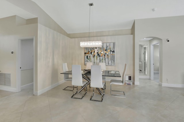 dining room with an inviting chandelier, vaulted ceiling, and light tile patterned floors