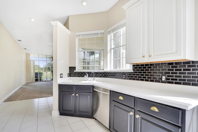 kitchen with dishwasher, light tile patterned floors, backsplash, white cabinets, and sink