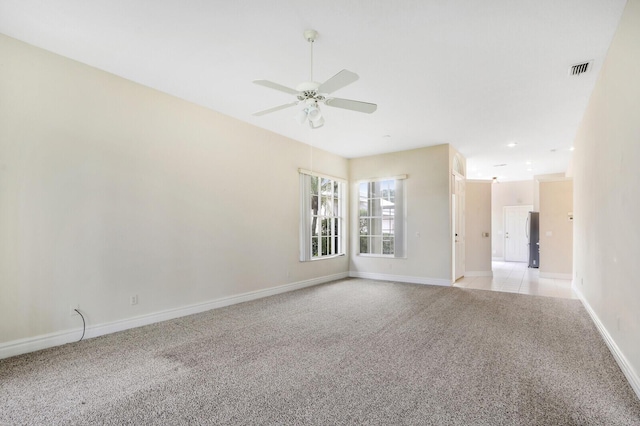 spare room featuring light carpet and ceiling fan