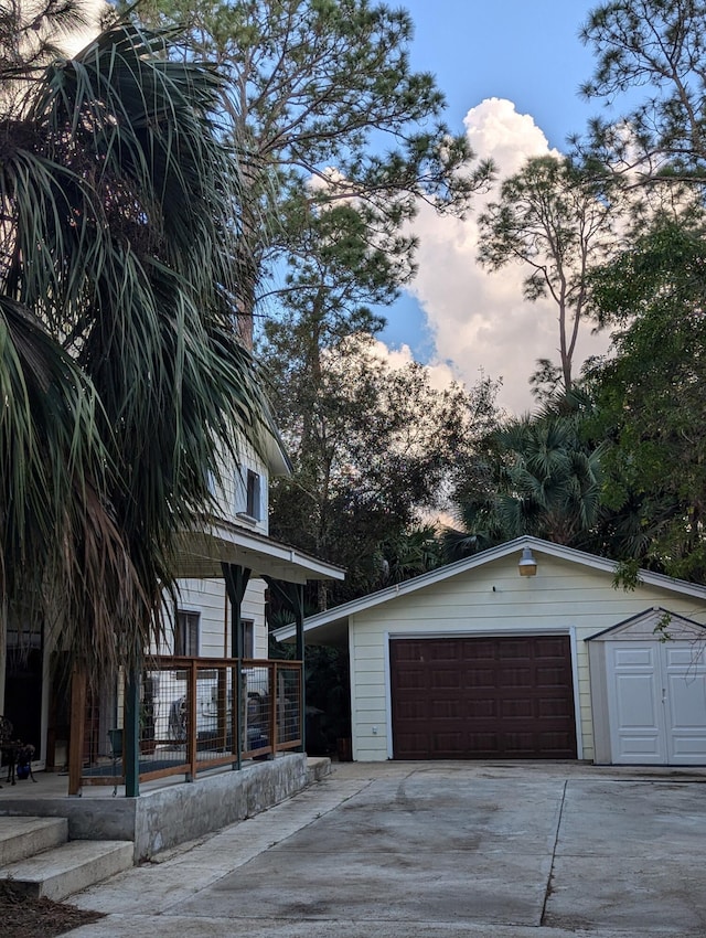 view of front of home featuring a garage, a porch, and an outdoor structure