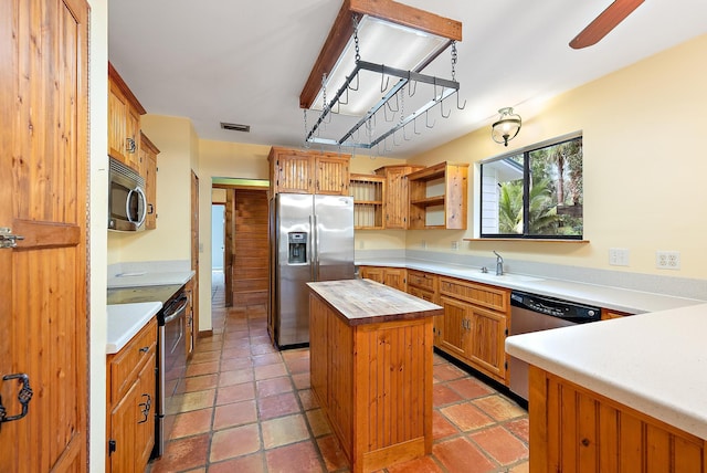 kitchen featuring stainless steel appliances, a center island, and sink